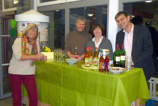 Eine Gruppe von Personen, versammelt um einen Stehtisch mit Getränken zu einer Veranstaltung.