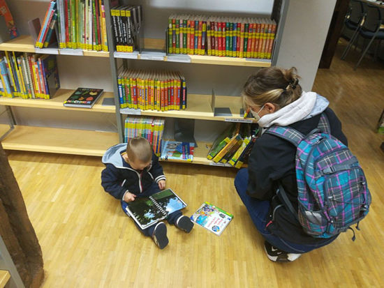 Kind mit Mutter in der Bibliothek