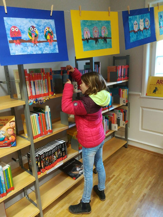 Kind stöbert im Bücherregal